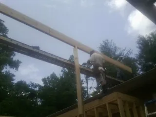 Carpenter setting a ridge beam over a new addition frame — Ice Dam Removal by Roofing Brothers in Tryon