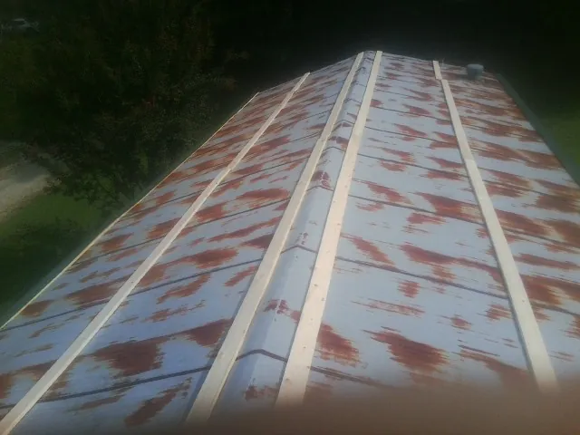 Rusted metal roof panels with new wood purlins before replacement — Storm Damage Roof Repair in Tryon by Roofing Brothers