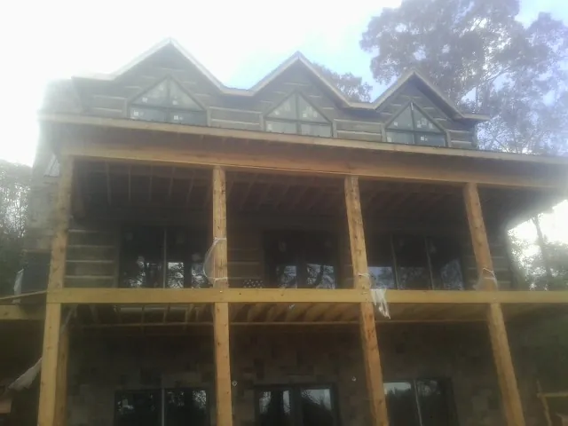 Dormers and porch framing on a large log home under construction — Roof Coating work by our crew in Tryon